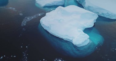 Su altında eriyen buzdağı yüzen kutup okyanusu. Çarpışan buzuldan kopan buz mavi soğuk suya sürükleniyor. Ekoloji, eriyen buz, iklim değişikliği, küresel ısınma kavramı. Panoramayı kapat