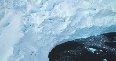 Antarktika 'da buzul mavisi bir buzul. Güneşli bir günde karla kaplı büyük buzdağı yüzeyi havadan yakın uçakla kaplandı. Kutup dondurucu doğa güzelliği. Kış dönemi. Güney Kutbu 'nu keşfet. Ekoloji