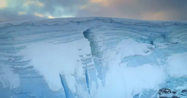 stock image Towering ice cliff in sunset Antarctic landscape, toward colorful sky. Breathtaking scene of an Antarctica iceberg. Arctic environment preserve of ice. Huge high glacier at polar nature. Aerial shot