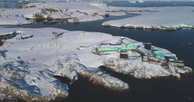 South Pole science polar station in Antarctica. Research Vernadsky base buildings on ocean coastline aerial drone view. Global warming, climate change, wild nature exploration. Antarctic expedition