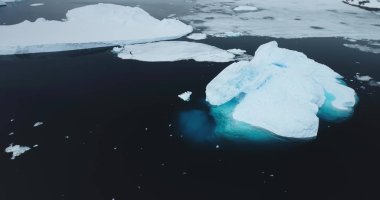 Antarktika 'da soğuk okyanusta eriyen mavi su buzdağları. Buz kütleleri hava aracı atışı. Kuzey Kutbu 'nda buzlar korunuyor. Küresel ısınma ve iklim değişikliğinin ekolojik sorunu