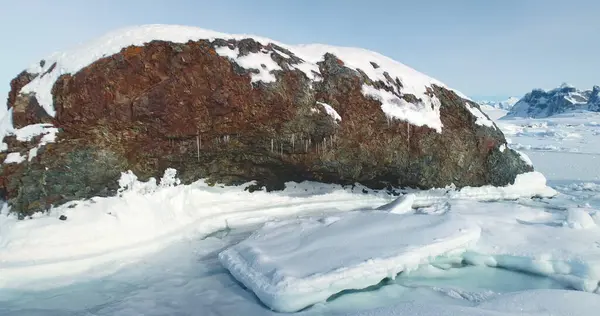 stock image Massive rock on snow-covered ground in Antarctica. Arctic snow mountain winter landscape. Untouched wilderness of South Pole wild nature. Frozen Arctic snowy land. Travel, explore. Low angle panorama