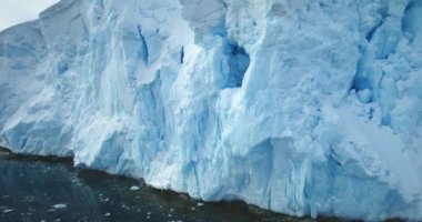 Güzel Antarktika mavi buzulları yükselen kutup okyanusları. Büyük buz dağı oluşumu parlak güneşin altında buzağıya dönüşüyor, soğuk su üzerinde yüzüyor. Eriyen buz, küresel ısınma, iklim değişikliği kutup manzarası