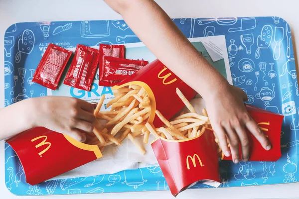 Poznan, Polonya - 18 Temmuz 2018. Çocuklar bir McDonald 's restoranında cips için uzanıyorlar.