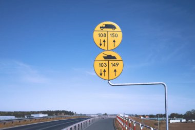 Mavi gökyüzü geçmişi olan bir köprüde Polonya askeri yol işaretleri.