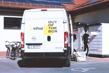 Sulechow, Polonya - 27 Eylül 2024. Paketleri bir paket dolabına yerleştiren bir InPost kuryesi. InPost, Polonya ve diğer Avrupa ülkelerinde faaliyet gösteren büyük bir kurye şirketidir..