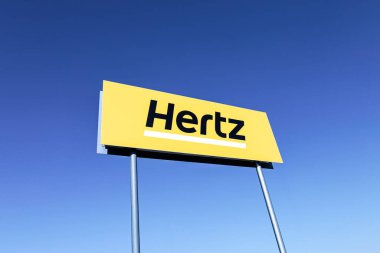 Poznan, Polonya - 22 Şubat 2025: Hertz logosu mavi gökyüzü arka planına sahip - Hertz, ABD 'li uluslararası araba kiralama şirketi..