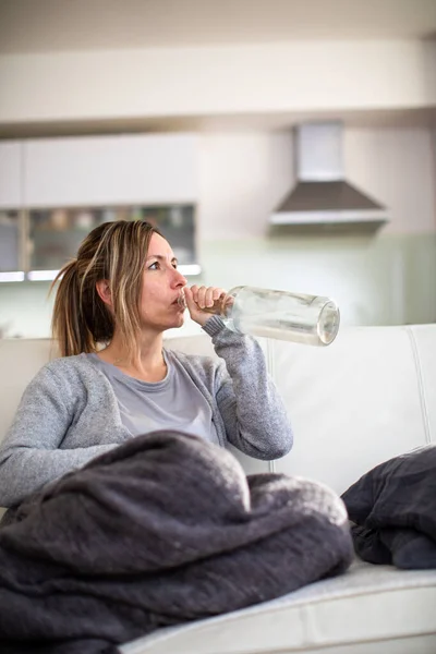 Vrouw Van Middelbare Leeftijd Thuis Met Een Fles Sterke Alcohol — Stockfoto