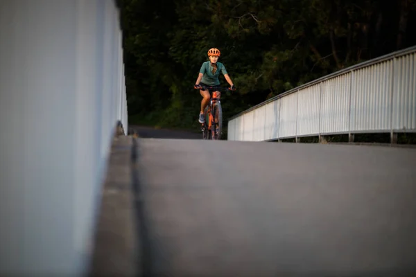 年轻的女人骑着她的山地自行车 骑着车过了城市的界限 每天都在做有氧运动 — 图库照片