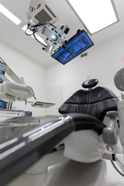 Dental treatment clinic interior with modern patient chair and a TV above
