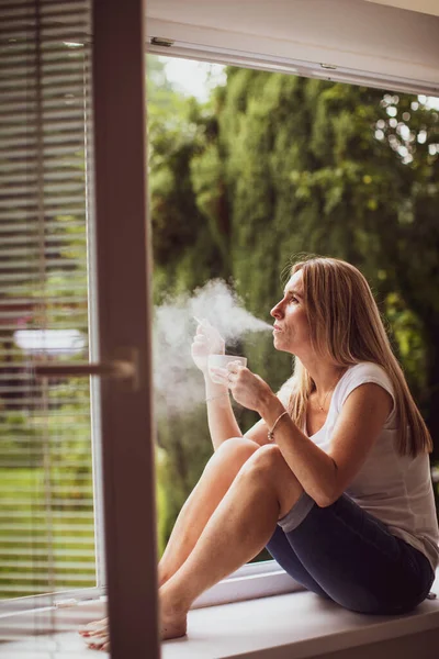 Vrouw Van Middelbare Leeftijd Die Thuis Een Sigaret Opsteekt Haar — Stockfoto