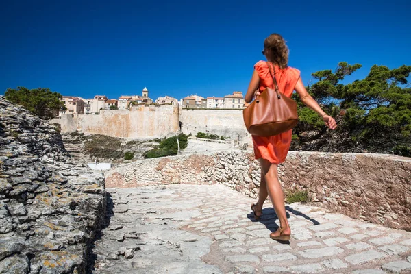 年轻的女游客欣赏法国科西嘉岛南岸的石灰岩悬崖博尼法乔老城 免版税图库图片