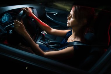 Geceleri araba sürmek - güzel, genç bir kadın gece modern arabasını sürüyor, bir şehirde (sığ DOF; renk tonlu görüntü))