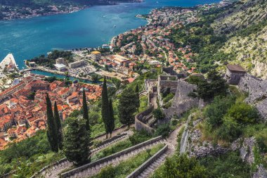 Tourist path to ancient Old Town around St John Fortress above historic part of Kotor town, Montenegro clipart