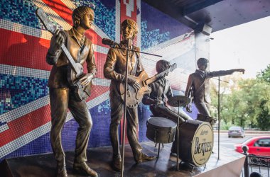 Donetsk, Ukraine - May 20, 2014: Statues of members of The Beatles band in front of Liverpool Hotel and Club in Donetsk during War in Donbas region clipart