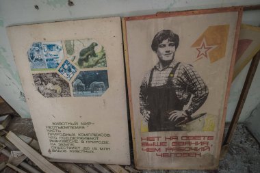 Pripyat, Ukraine - October 2, 2014: Posters in Middle School No. 3 in Pripyat ghost city in Chernobyl Exclusion Zone clipart