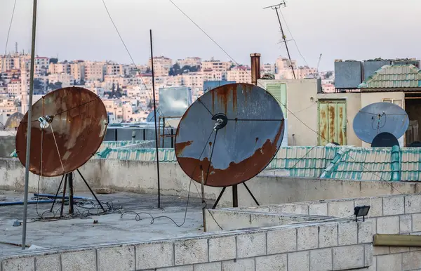 stock image Amman, Jordan - December 23, 2015: Rusty satellite aeriala on the house roof in Amman city