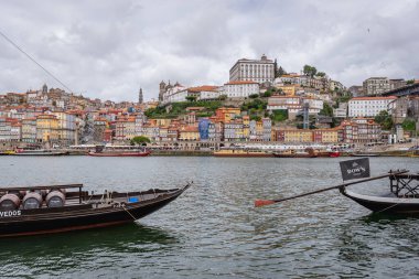 Vila Nova de Gaia, Portugal - July 6, 2021: Traditional Rabelo boats on Douro River bank in Vila Nova de Gaia, Portugal. View with Episcopal Palace in Porto clipart