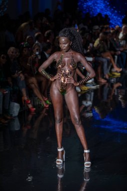 Miami Beach 'teki Faena Forum' da Sanat, Kalpler, Moda Yüzme Haftası sırasında Black Tape Project Moda Şovu için podyumda bir manken yürüyor.