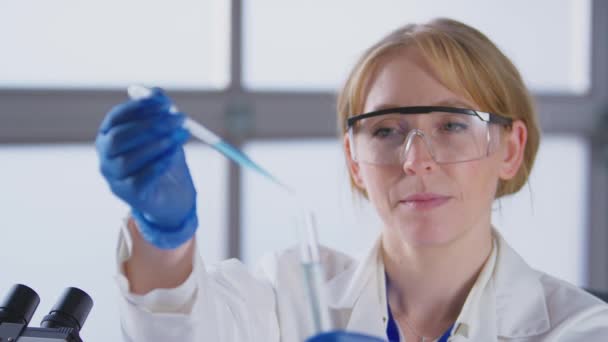 Trabalhadora Laboratório Usando Casaco Branco Adicionando Líquido Azul Pipeta Tubo — Vídeo de Stock
