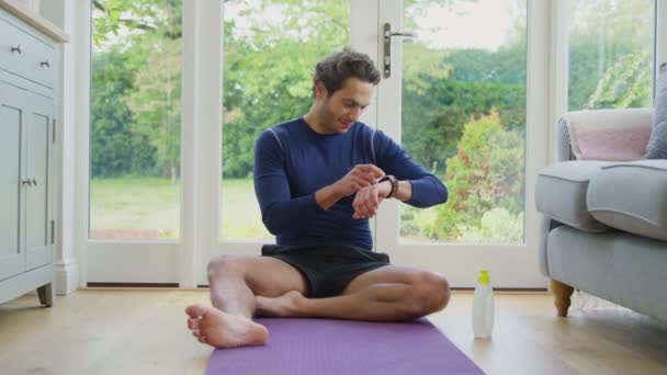 Mature Man Sitting Yoga Mat Home Exercise Looking Smart Watch — 비디오