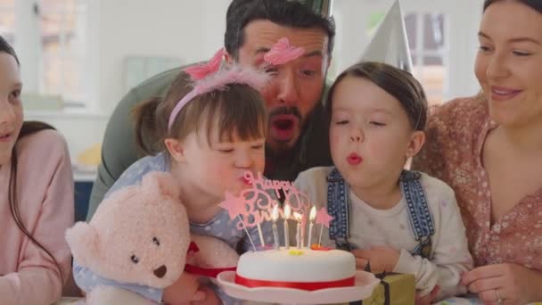 患有唐氏综合症的家庭的女儿在家里的厨房里围坐在桌子旁庆祝生日 并在蛋糕上吹灭蜡烛 动作缓慢 — 图库视频影像