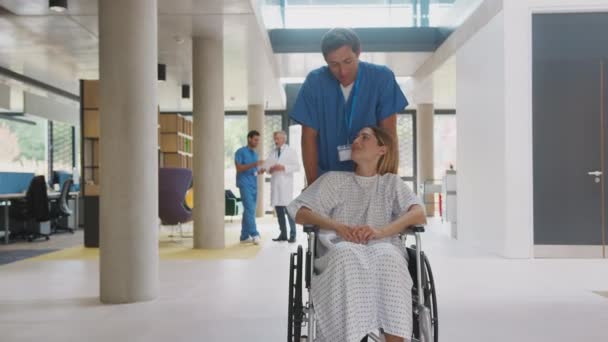 Önlük Giyen Erkek Hemşire Tekerlekli Sandalyedeki Kadın Hastayı Ağır Çekimde — Stok video