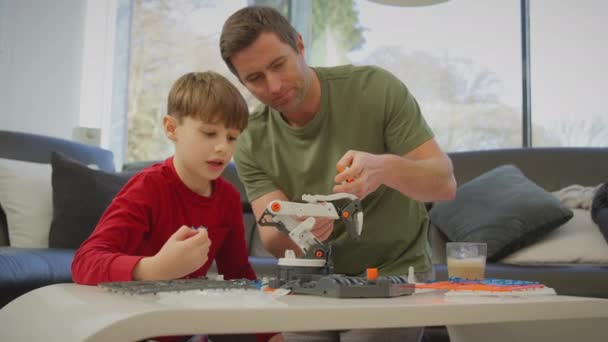 Ayah Dan Anak Memakai Piyama Untuk Membangun Lengan Robot Dari — Stok Video