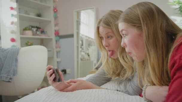 휴대폰으로 포즈를 취하기 침대에 잠옷을 어머니의 동작으로 — 비디오