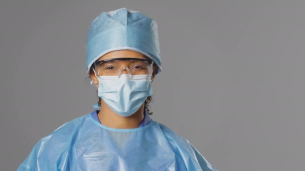 마스크와 배경에 안경을 착용하고 수술복을 외과의사의 스튜디오 동작으로 — 비디오