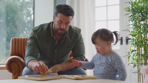 唐氏综合症女孩和父亲一起在家里玩拼字游戏 慢动作射击 — 图库视频影像