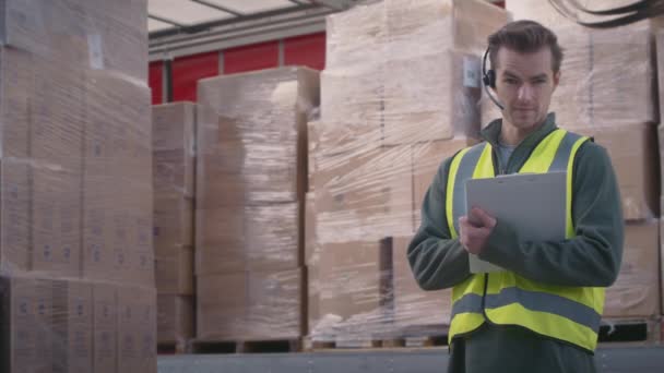 Άνδρας Εργαζόμενος Επιχείρηση Εμπορευματικών Μεταφορών Φορώντας Ακουστικά Στέκεται Δίπλα Στο — Αρχείο Βίντεο