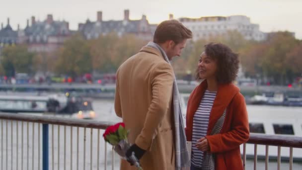 秋のカップルや秋の会議ロンドンの日付で男とテムズ川で女性の贈り物や花の花束を与えます スローモーションで撮影 — ストック動画