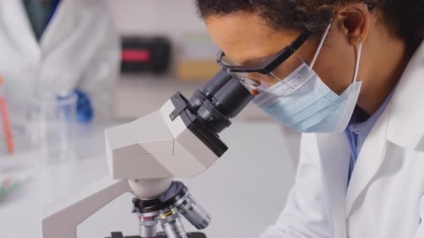 女性研究室の労働者や血液サンプルを顕微鏡で分析する植物学者の閉鎖 スローモーションで撮影 — ストック動画