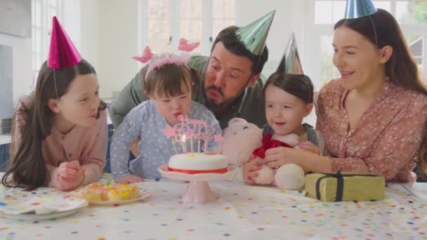 患有唐氏综合症的家庭的女儿在家里的厨房里围坐在桌子旁庆祝生日 并在蛋糕上吹灭蜡烛 动作缓慢 — 图库视频影像