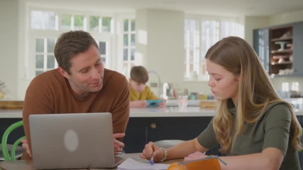 Föräldrar Hjälper Tonårsdotter Med Läxor Sittandes Vid Köksbordet Hemma Med — Stockvideo