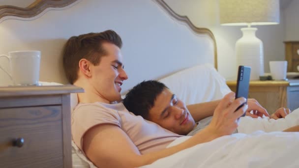 Kochająca Samą Płeć Para Leżąca Łóżku Mężczyzną Robiącym Selfie Przez — Wideo stockowe