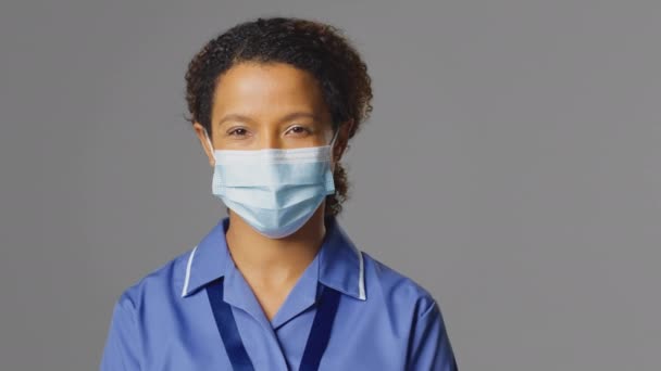 Studio Portrét Ošetřovatelky Uniformě Obličejové Masce Šedém Pozadí Záběr Zpomaleném — Stock video