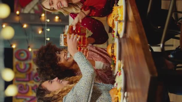 複数文化の女性の友人のグループの垂直ビデオテーブルで食事を食べ 女の子の夜を一緒に楽しむ スローモーションで撮影 — ストック動画