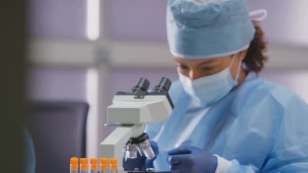 Trabalhadora Laboratório Que Usa Epi Analisando Amostras Laboratório Com Microscópio — Vídeo de Stock