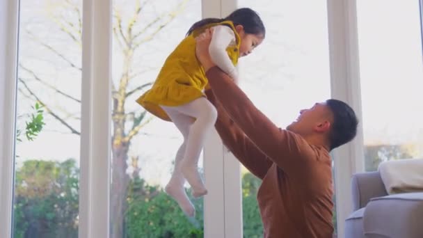 Rodzina Bawiąca Się Domu Tatą Podnoszącym Śmiejącą Się Córkę Powietrze — Wideo stockowe