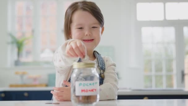 Girl Saving Money Jar Labelled Pocket Money Kitchen Counter Home — Stock Video