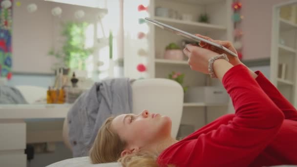 十几岁的女孩 戴着正牙矫正器 躺在床上 用数字平板镜头慢动作拍摄 — 图库视频影像
