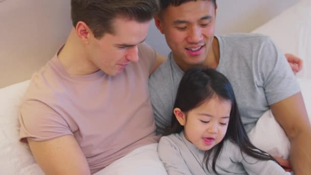 Familie Mit Zwei Vätern Hause Bett Und Liest Tochter Gemeinsam — Stockvideo