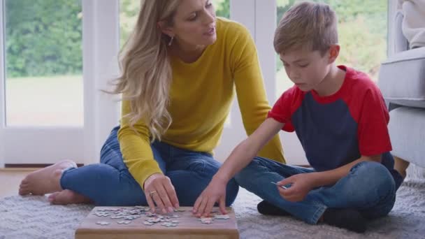 母亲和儿子在家里的休息室地板上一起做拼图游戏 动作缓慢 — 图库视频影像
