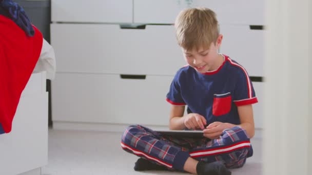 Evde Yatak Odasında Pijamalı Bir Çocuk Yerde Oturup Dijital Tabletle — Stok video