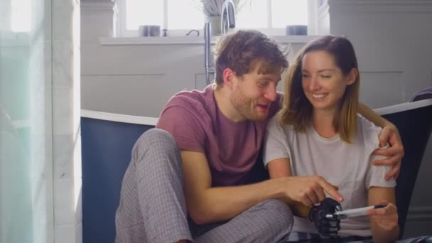 興奮したカップルとともに女性とともに義肢でバスルームの床に座っています正妊娠テスト スローモーションで撮影 — ストック動画