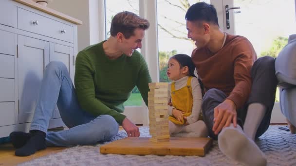 Οικογένεια Δύο Μπαμπάδες Παίζουν Παιχνίδι Την Κόρη Στο Σπίτι Στοίβαγμα — Αρχείο Βίντεο