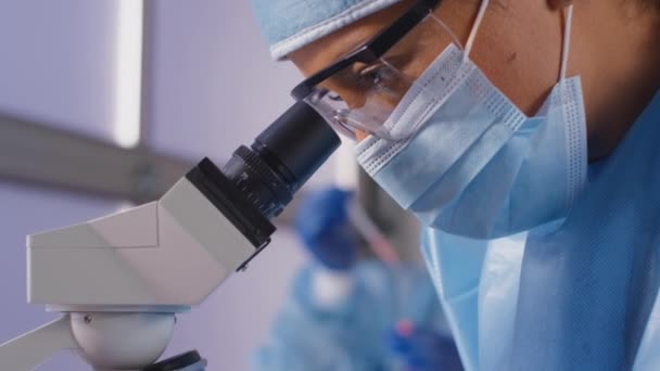 Pracownica Laboratorium Nosząca Śoi Analizujące Próbki Mikroskopem Posiadającym Szczepionkę Znakowaną — Wideo stockowe