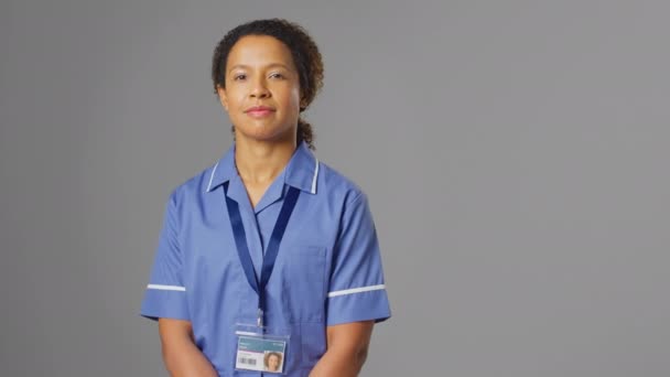 Studio Portret Van Glimlachende Verpleegster Dragen Uniform Tegen Grijze Achtergrond — Stockvideo